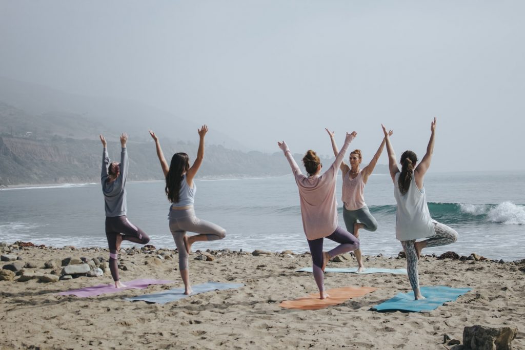 People doing yoga on a beach